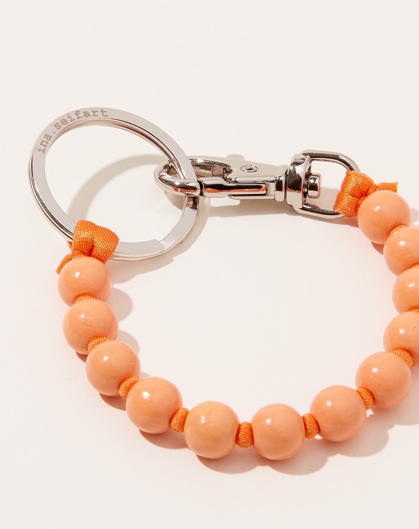 Ina Seifart Perlen Short Keyholder in Peach on Orange