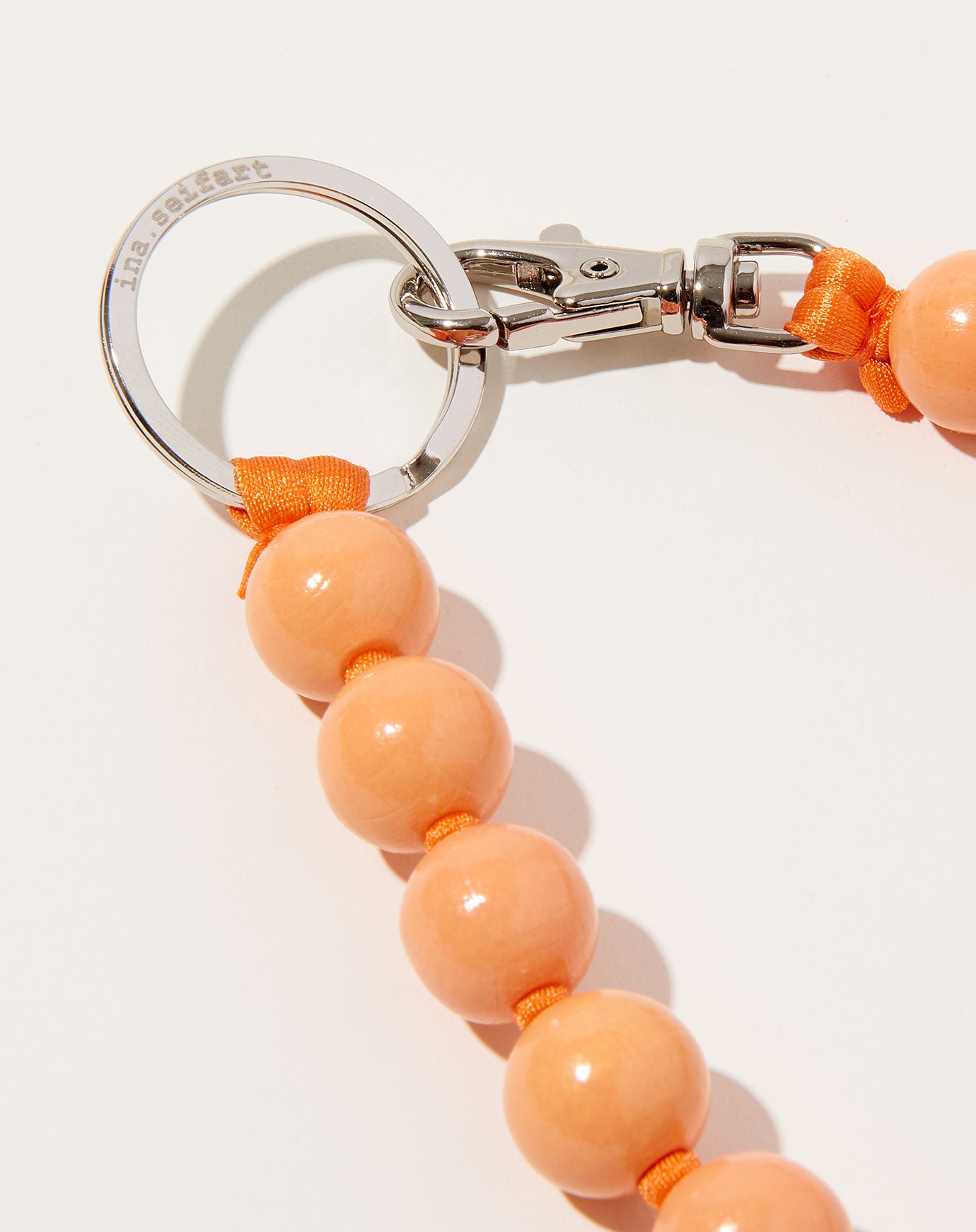 Ina Seifart Big Perlen Long Keyholder in Peach on Orange