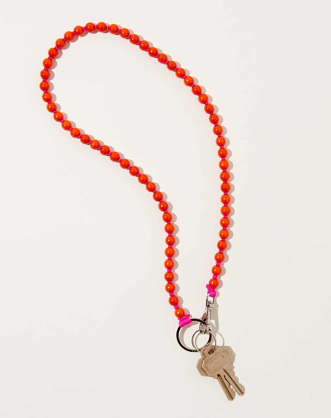 Ina Seifart Perlen Long Keyholder in Orange on Pink